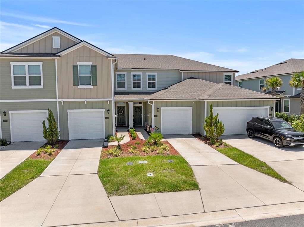 146 Redbud Road Palm Coast, FL 32137 - Photo 2 of 40 a front view of a house with a garden and pathway