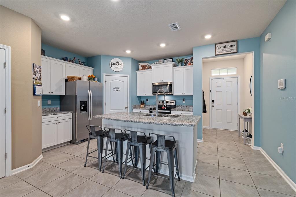 146 Redbud Road Palm Coast, FL 32137 - Photo 3 of 40 a kitchen with stainless steel appliances a refrigerator and microwave