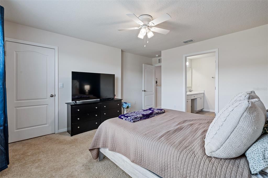 146 Redbud Road Palm Coast, FL 32137 - Photo 32 of 40 a bedroom with a bed and a flat screen tv