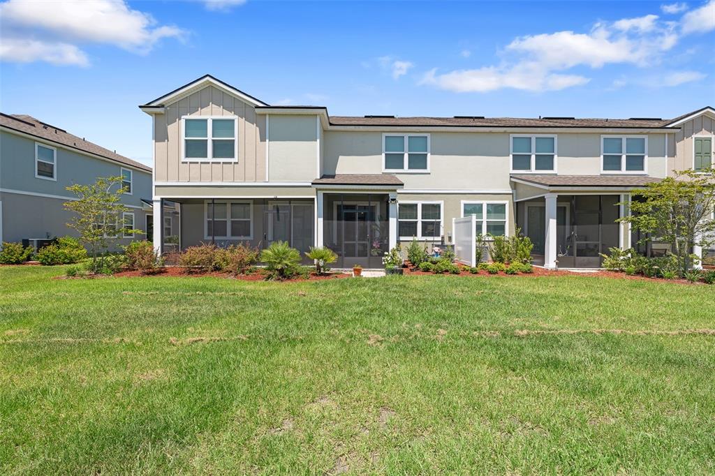 146 Redbud Road Palm Coast, FL 32137 - Photo 35 of 40 a front view of a house with a yard and potted plants