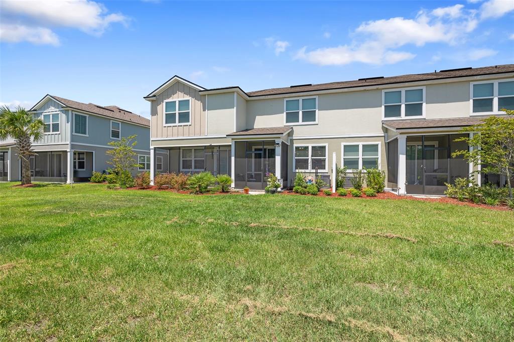 146 Redbud Road Palm Coast, FL 32137 - Photo 37 of 40 a front view of a house with a yard and potted plants