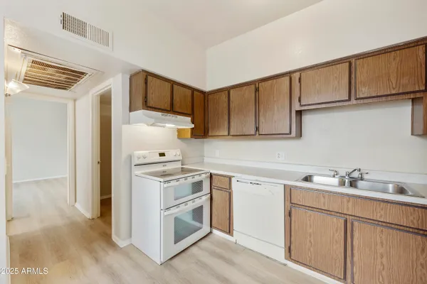 a kitchen with cabinets stainless steel appliances and wooden floor
