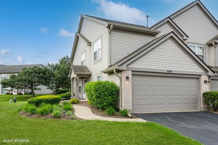 a view of a white house next to a yard