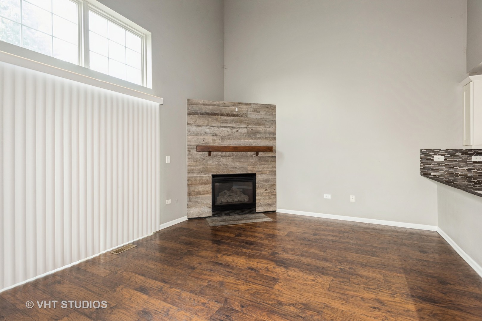 644 Lancaster Circle Elgin, IL 60123 - Photo 5 of 21 a view of an empty room with wooden floor fireplace and a window