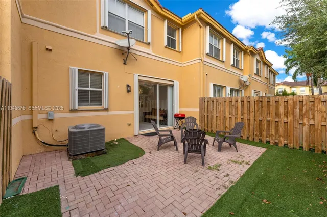 a front view of a house with a chairs and table in patio
