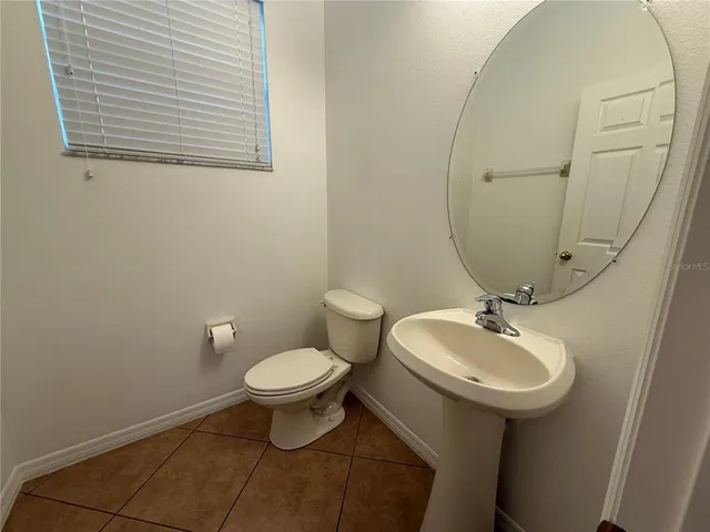 a bathroom with a sink toilet and a mirror