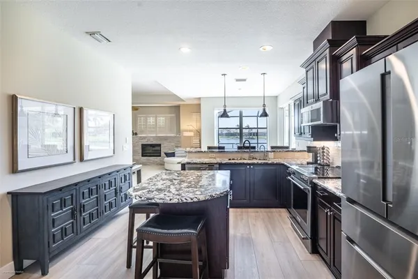 a kitchen with granite countertop wooden cabinets a stove and a window