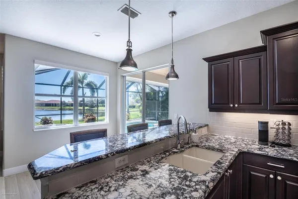 a living room with furniture a kitchen island with furniture and kitchen view