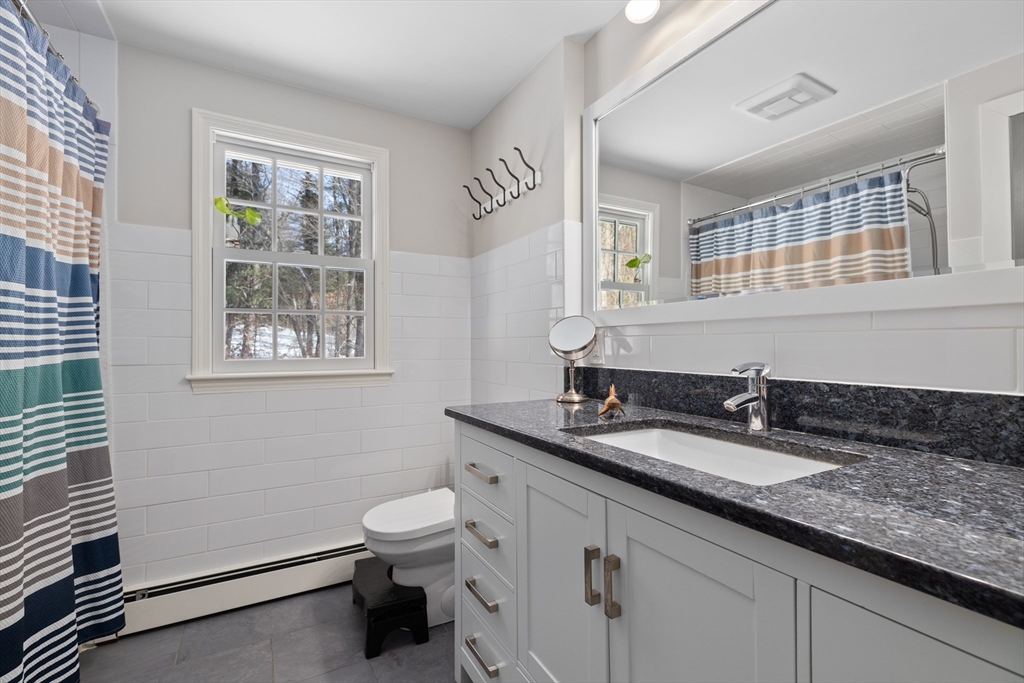 180 Rowley Bridge Road Topsfield, MA 01983 - Photo 23 of 42 a bathroom with a granite countertop sink a toilet and a mirror