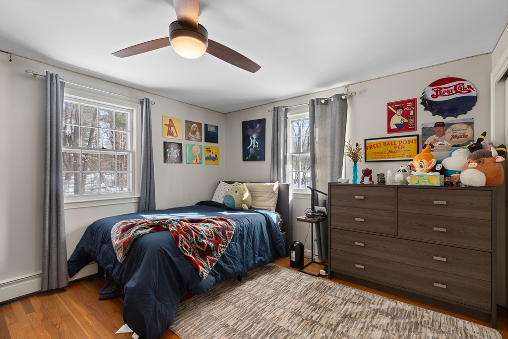 180 Rowley Bridge Road Topsfield, MA 01983 - Photo 25 of 42 a bedroom with a bed and a chandelier