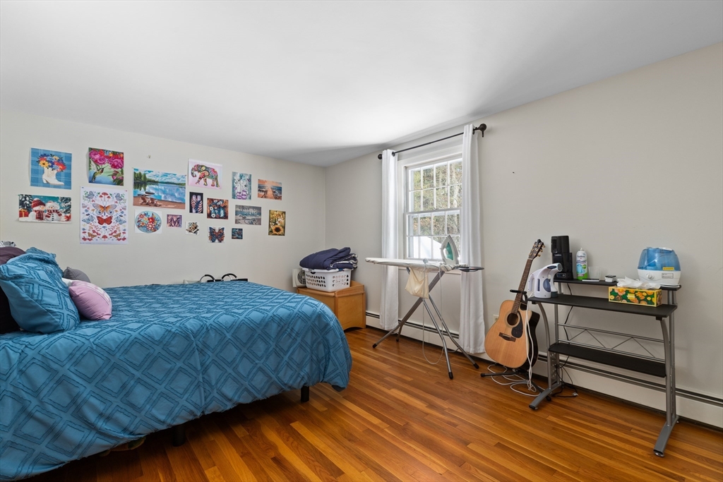 180 Rowley Bridge Road Topsfield, MA 01983 - Photo 27 of 42 a bedroom with a bed and wooden floor