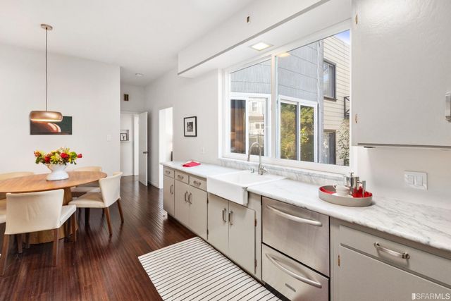 a large white kitchen with a sink and dish washer
