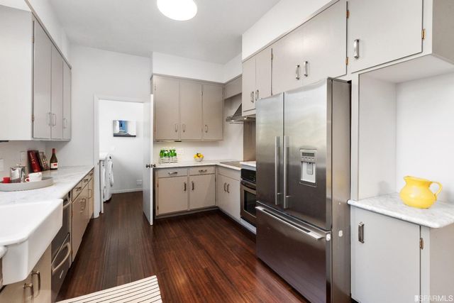 a kitchen with a sink a refrigerator and cabinets