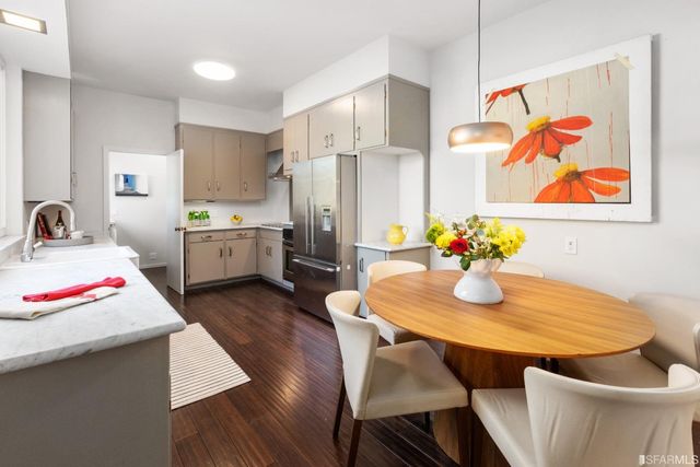 a dining room with stainless steel appliances kitchen island granite countertop a dining table and chairs