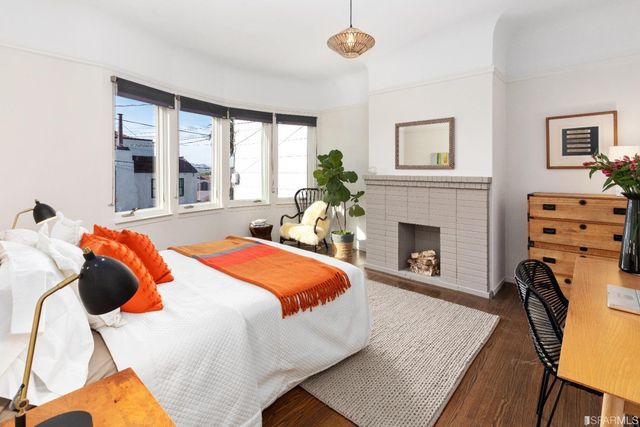 a bedroom with a bed a fireplace and a large mirror