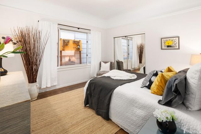 a bedroom with a bed and wooden floor