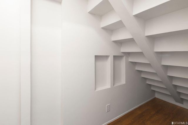 a view of a hallway with wooden floor and entryway