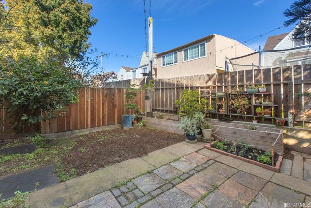 a garden with a bench in front of the house