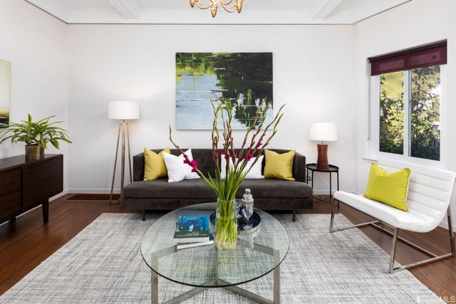 a living room with furniture flowerpot and wooden floor