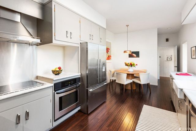a kitchen with stainless steel appliances a stove a sink cabinets and wooden floor