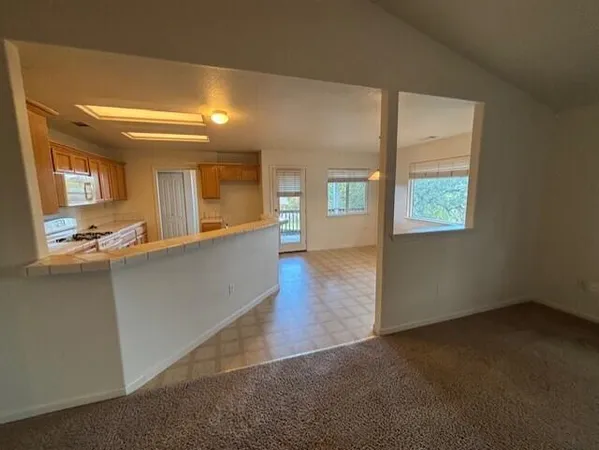 an empty room with a kitchen and windows