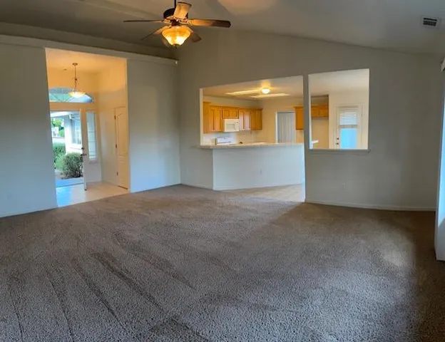 a view of a big room with wooden floor and chandelier