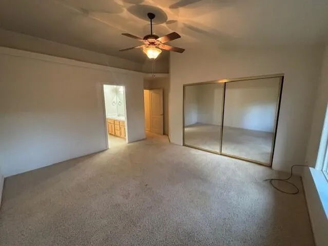 a view of an empty room with a chandelier fan