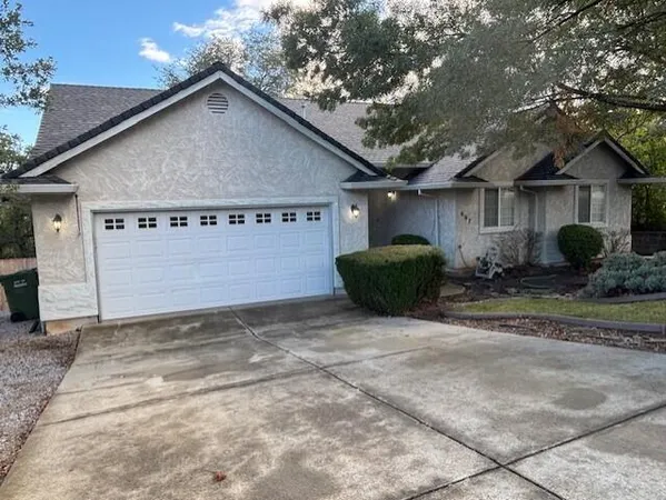 a view of a house with backyard and trees
