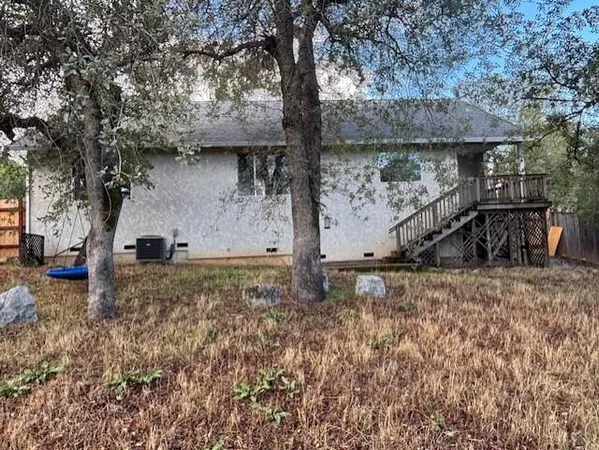 a view of a house with a yard and large tree