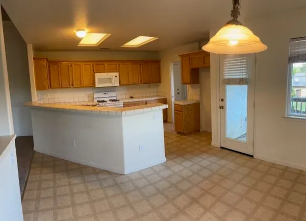 a kitchen with stainless steel appliances granite countertop a refrigerator and a stove top oven