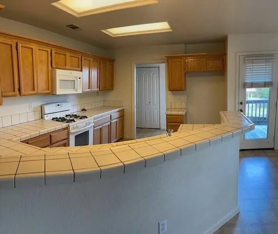 a kitchen with stainless steel appliances granite countertop a sink stove and cabinets