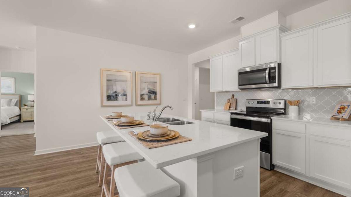 204 Cattle Drive Perry, GA 31069 - Photo 7 of 44 a kitchen with a stove a sink and a refrigerator