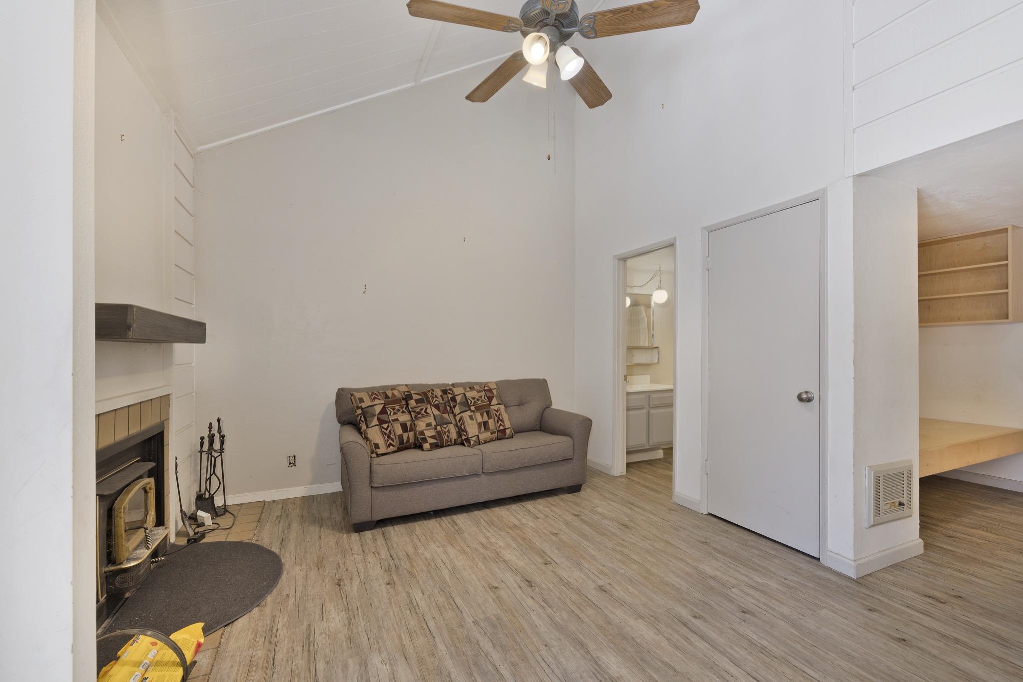 2289 Sierra Nevada Road, Unit G10 Mammoth Lakes, CA 93546 - Photo 11 of 23 Living area featuring light wood finished floors, lofted ceiling, ceiling fan, a tiled fireplace, and heating unit