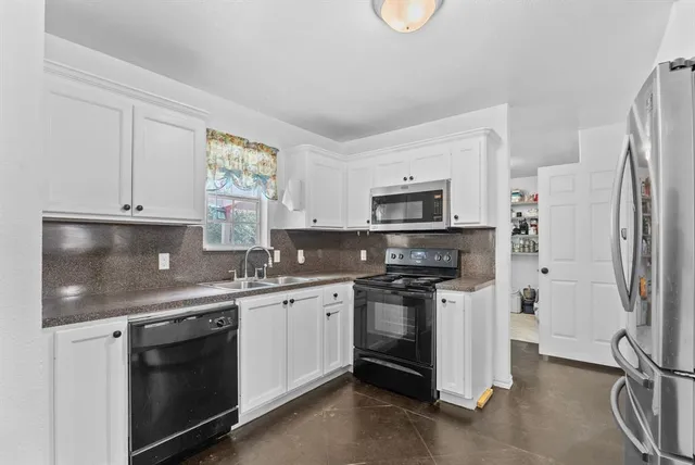 a kitchen with stainless steel appliances a stove sink and refrigerator