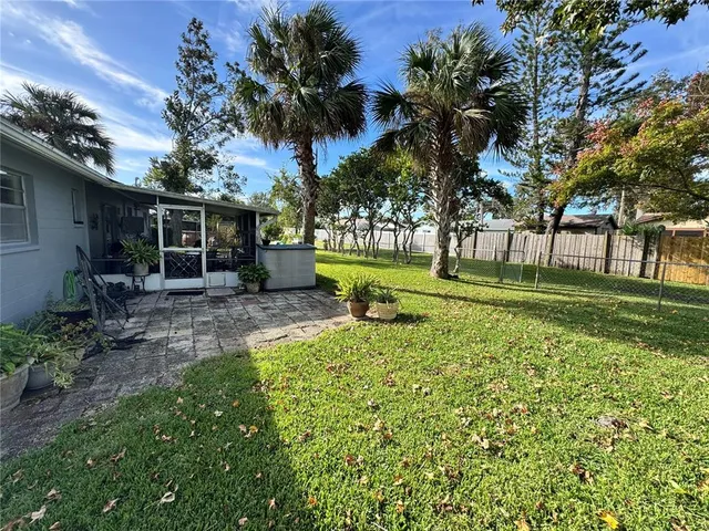 a backyard of a house with garden and outdoor seating
