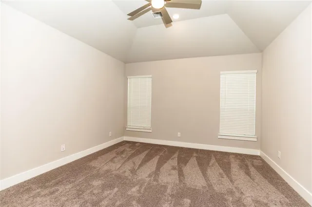 an empty room with a ceiling fan and window