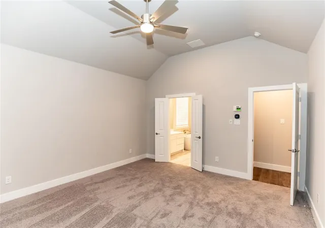an empty room with closet and a ceiling fan