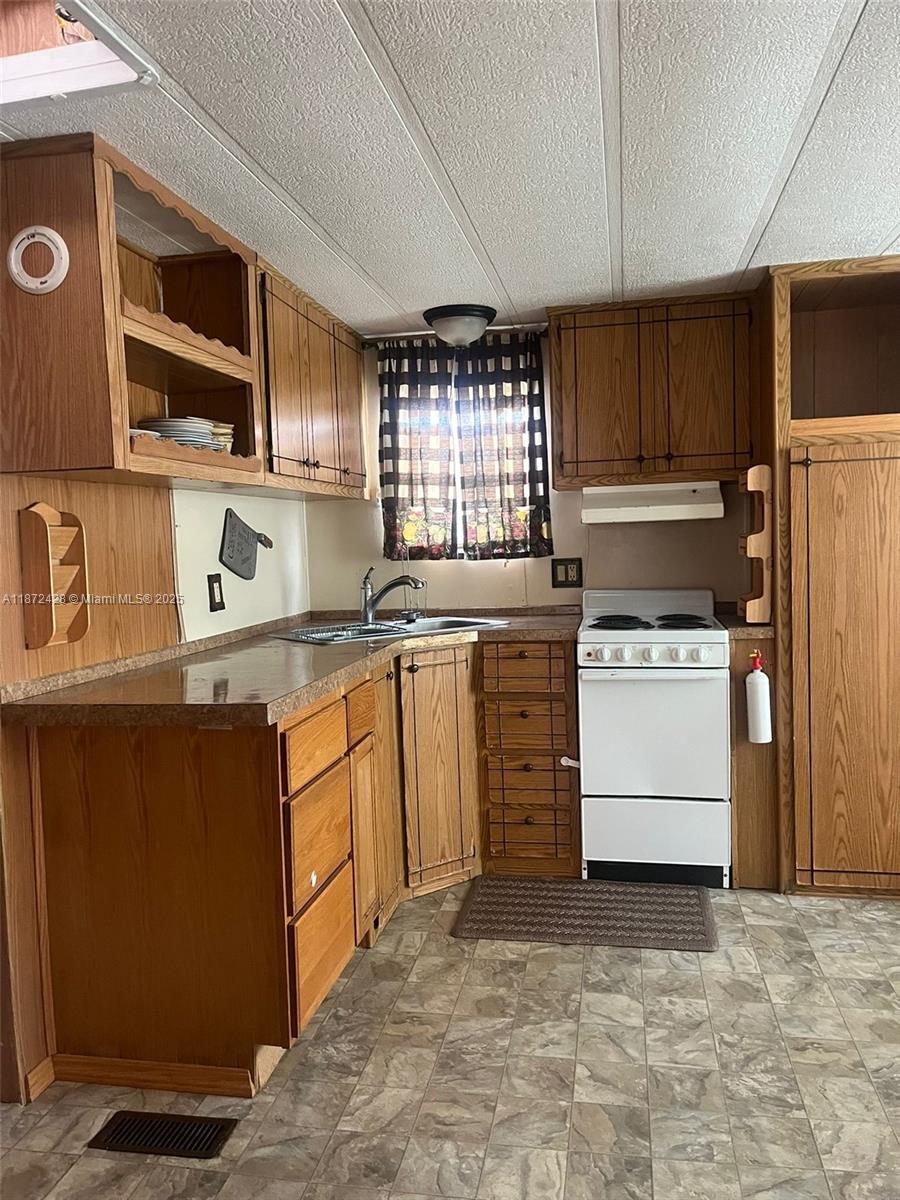 14725 Northwest 1st, Unit RV 4 Okeechobee, FL 34972 - Photo 7 of 11 a kitchen with a stove microwave and cabinets