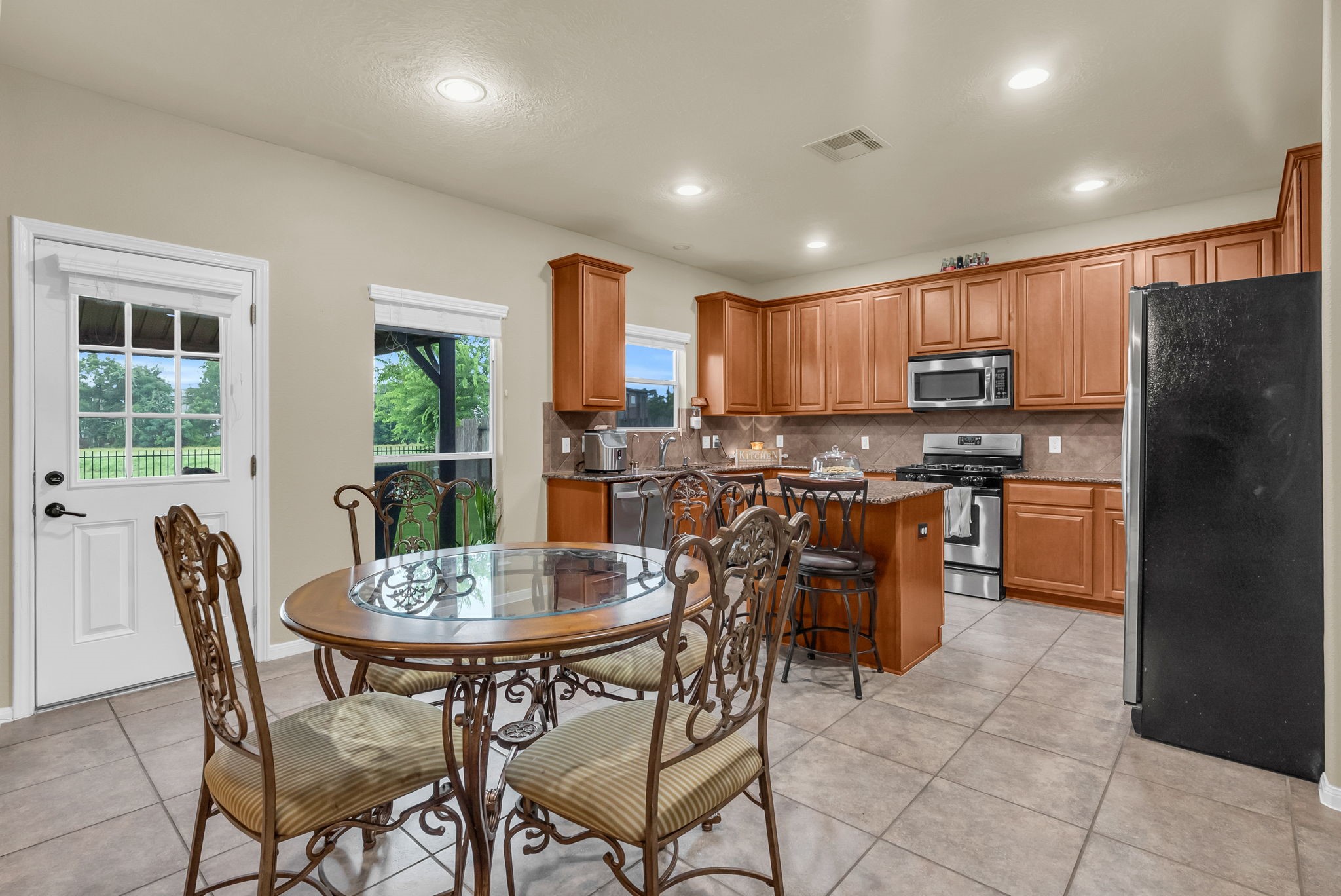 16619 Dover Mills Drive Spring, TX 77379 - Photo 14 of 49 a kitchen with stainless steel appliances granite countertop a stove a refrigerator a kitchen island and chairs with wooden floor