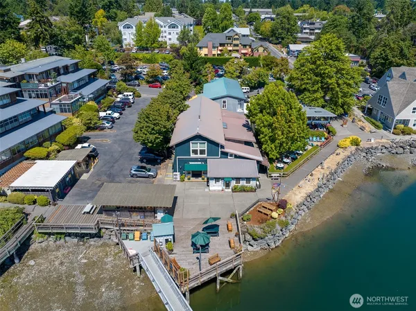 an aerial view of residential houses with outdoor space and lake view
