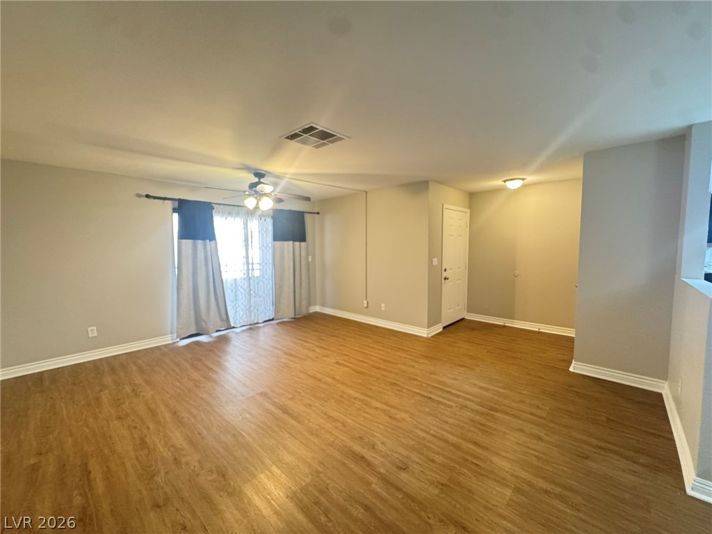 5141 South Lindell Road, Unit 102 Las Vegas, NV 89118 - Photo 5 of 17 A spacious living area featuring durable laminate flooring and direct access to an outdoor space.