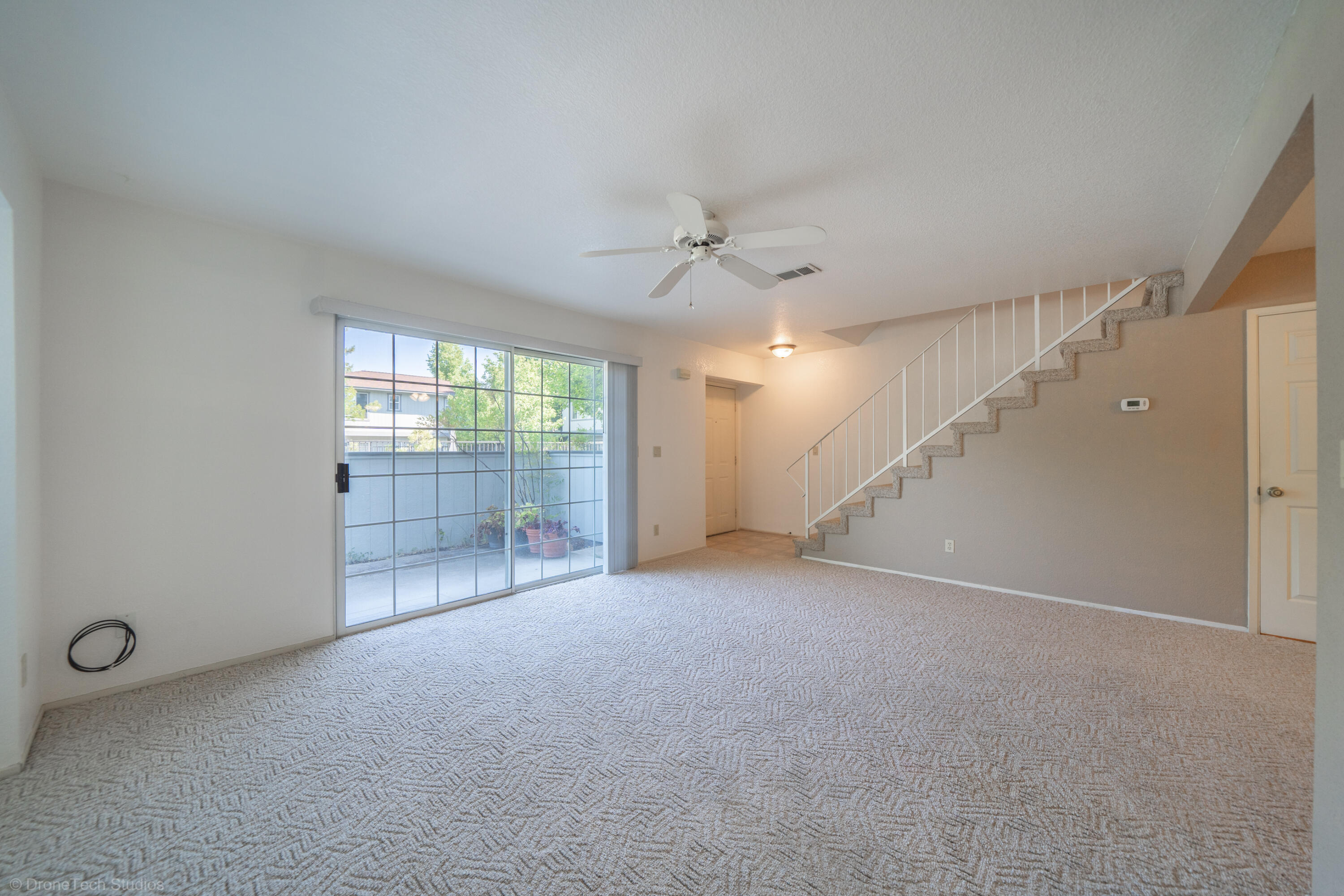 200 Ridgetop Drive, Unit 19 Redding, CA 96003 - Photo 13 of 53 an empty room with windows and a ceiling fan