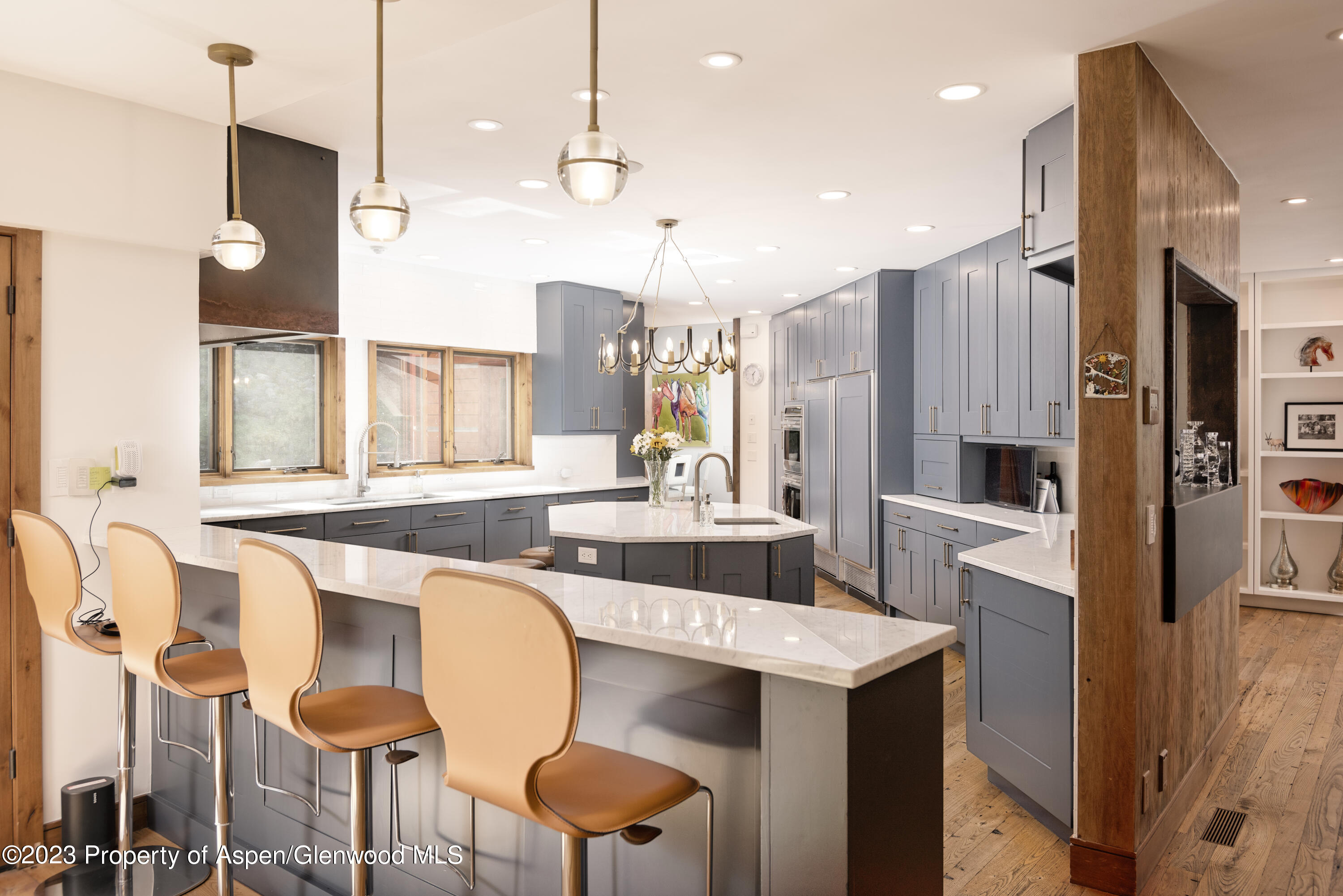 970 Powder Lane Aspen, CO 81611 - Photo 11 of 68 a kitchen with granite countertop a table chairs stove a refrigerator and cabinets
