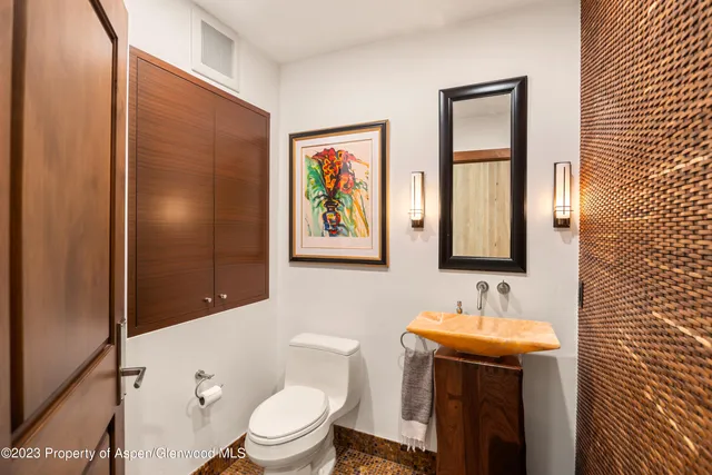 a bathroom with a granite countertop sink toilet and mirror