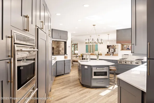 a dining room with wooden floor and large windows
