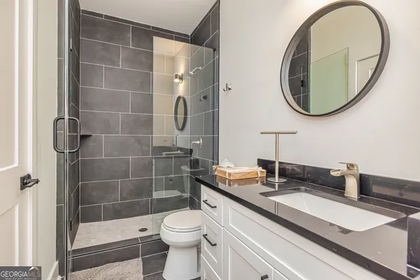 a bathroom with a sink a toilet and a mirror