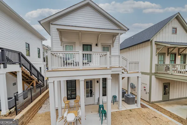 a view of a house with wooden deck and furniture