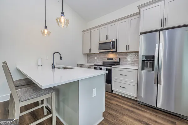 a kitchen with appliances a sink and cabinets
