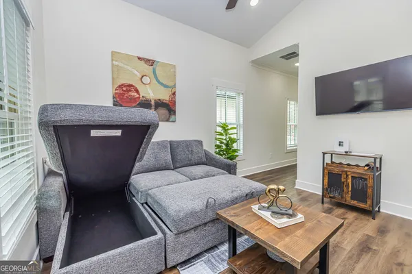 a living room with furniture and a wooden floor
