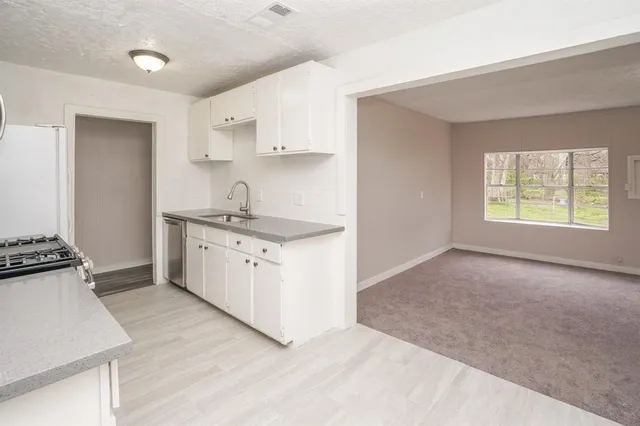 a kitchen with a sink stove and cabinets